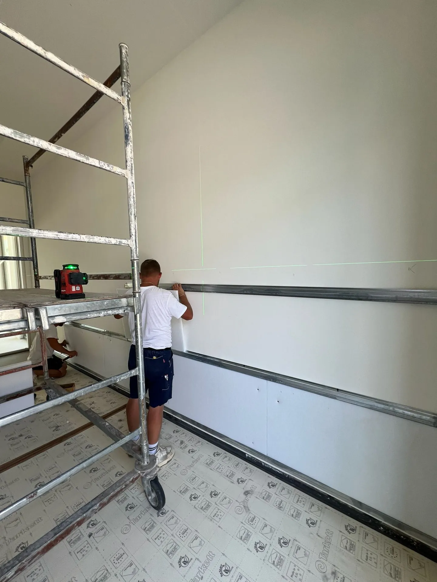 Operaio al lavoro sulla posa dei pannelli a parete